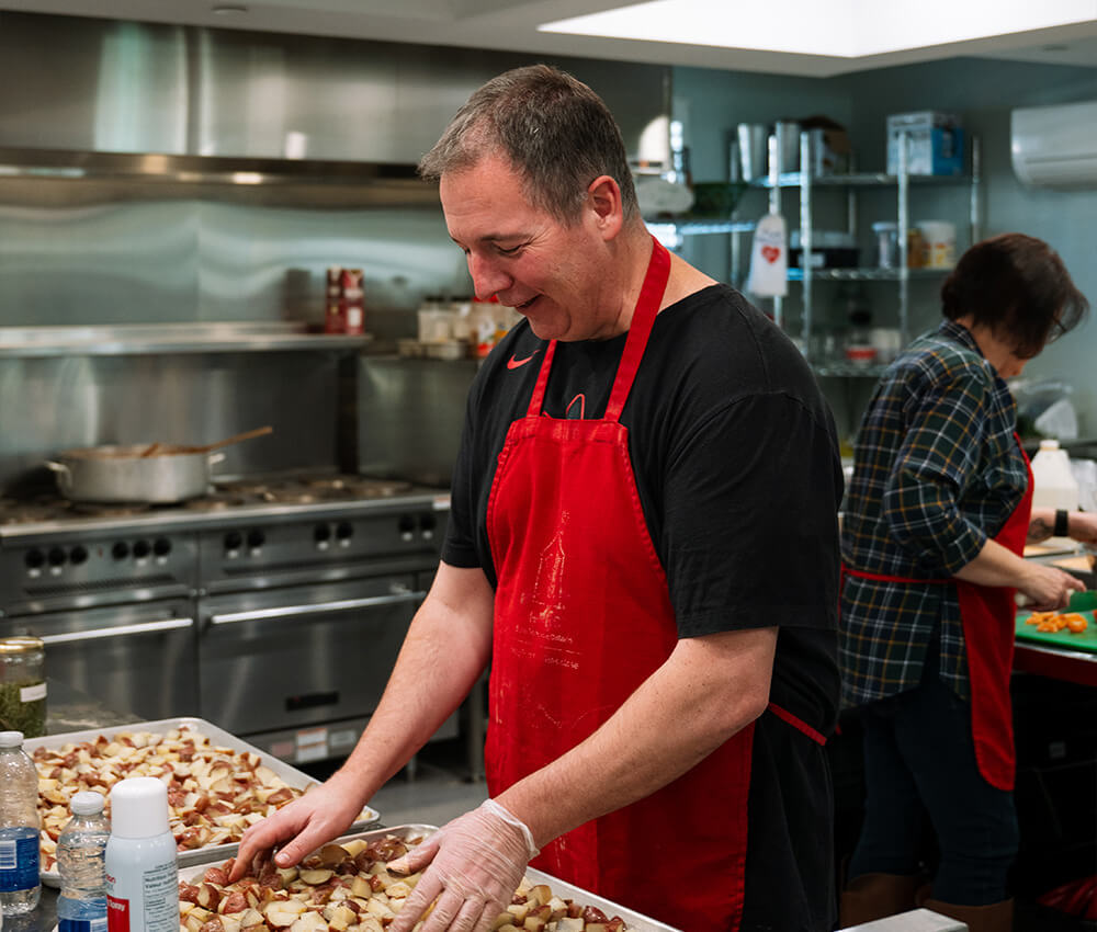 Volunteer helps prepare food in the kitchen