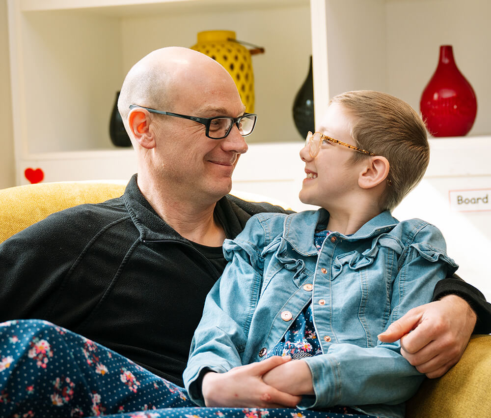 Child enjoys sitting with family